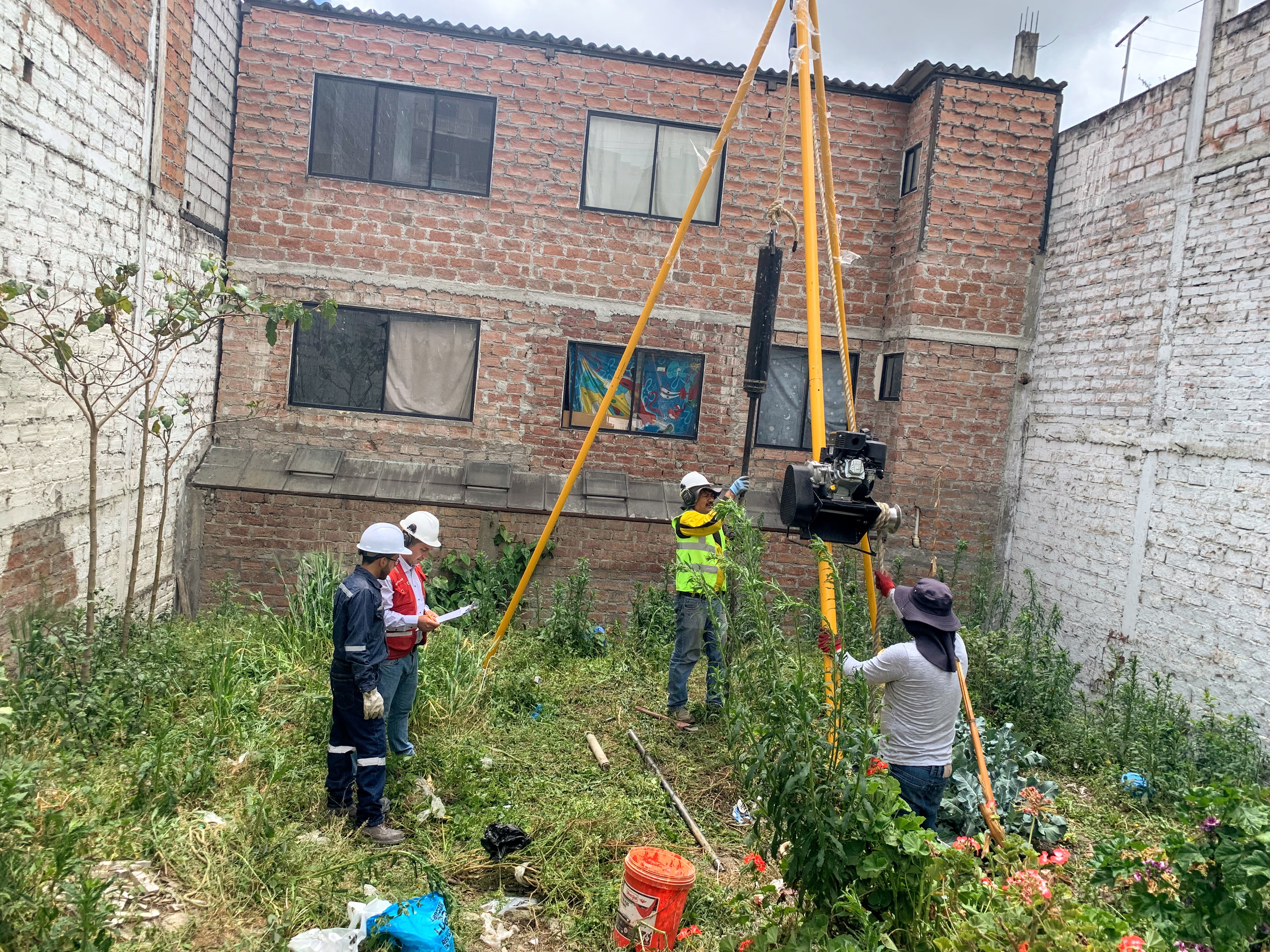 Equipo técnico realizando perforación en un terreno urbano